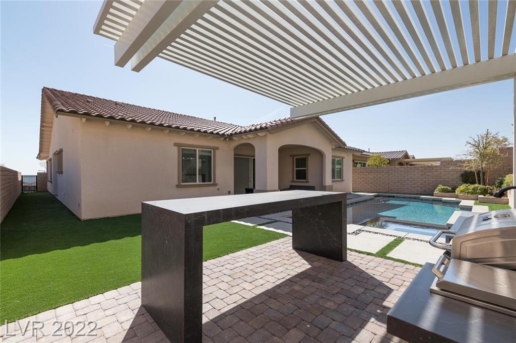Finished Impact project: pavers connecting the outdoor kitchen, pergola, turf and pool area