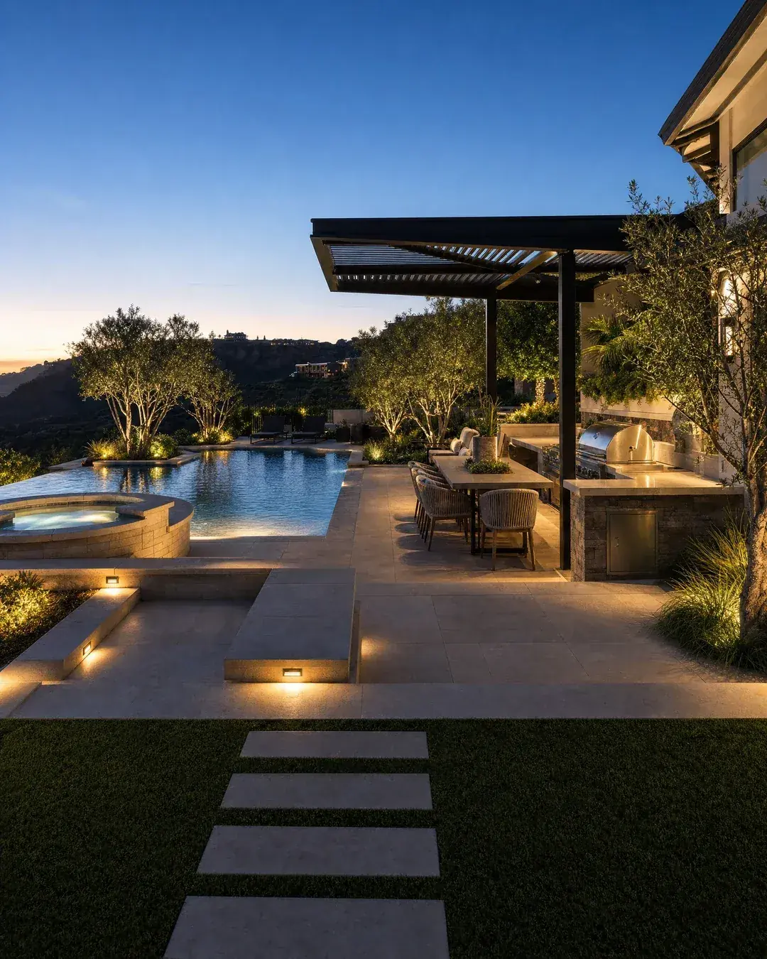 Illustrative evening backyard concept showing pool, spa and integrated landscape lighting