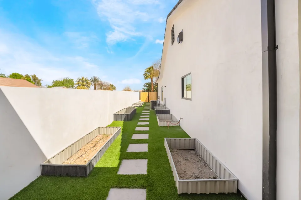 Completed side yard with turf, pathways, and planters